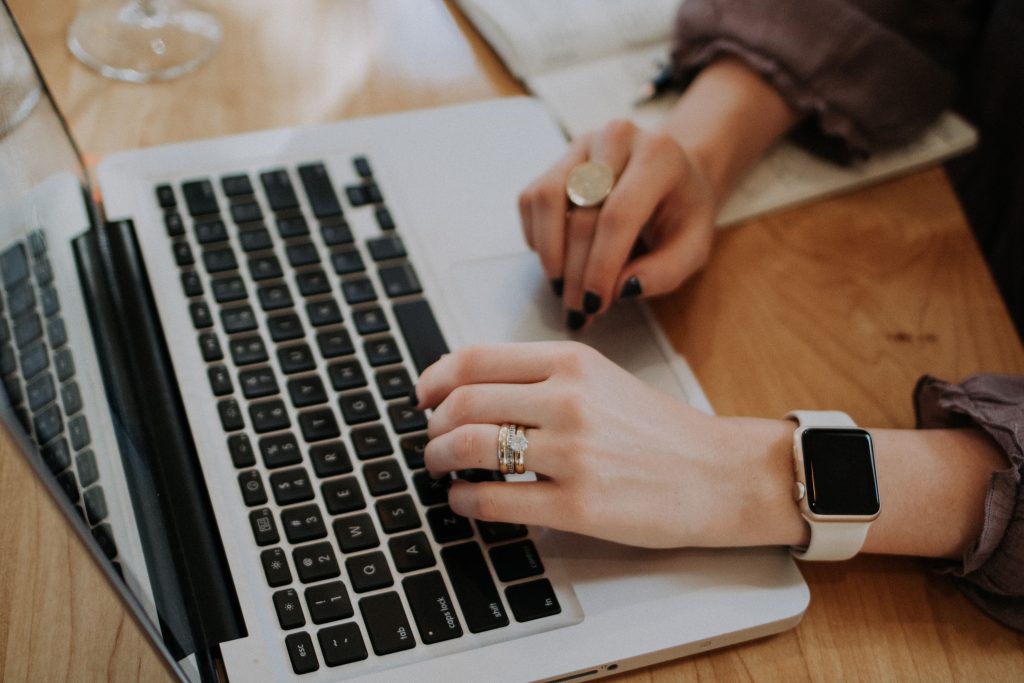 Woman typing on a laptop.