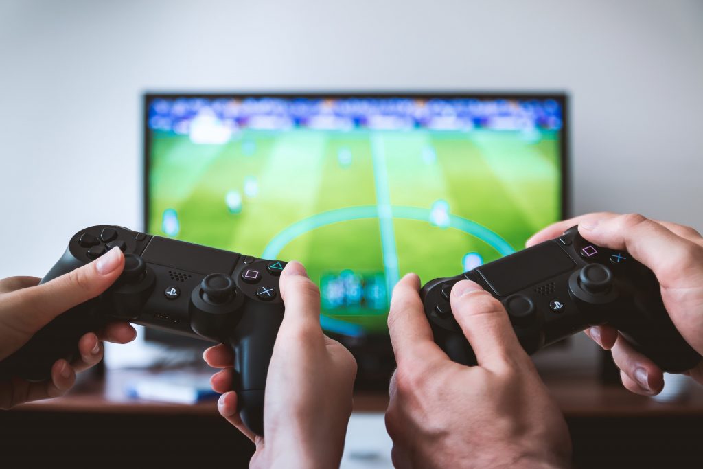 Two people playing FIFA on a TV.