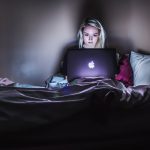 Woman watching Netflix in bed.